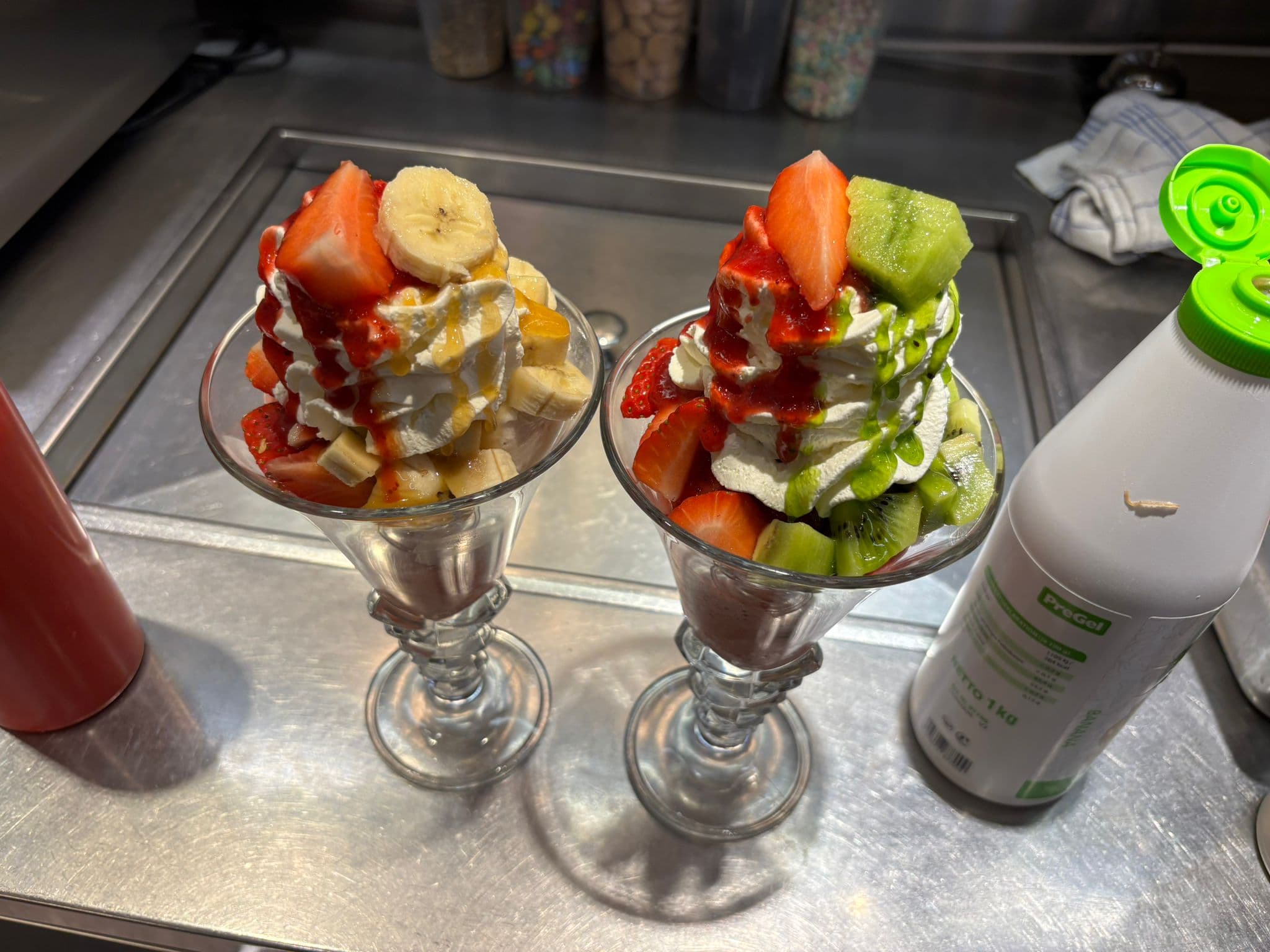 Eisbecher mit Erdbeer- und Kiwi-Eis, garniert mit frischen Früchten
